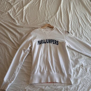 Vit fleece tröja från Parajumpers - Säljer en vit fleece tröja från Parajumpers med tryck på framsidan. Tröjan har långa ärmar och en rund halsringning. Perfekt för kyligare dagar. 🧥.  