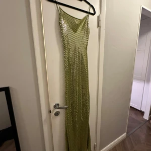 Grön paljettklänning från Rat & Boa - Snygg grön långklänning från Rat & Boa med glittrande paljetter och smala axelband. Perfekt för att sticka ut på festen med sin slimmade passform och glänsande look. ✨ nypris 3700kr, jag är 165cm lång och klänningen går ner till mina fötter💚