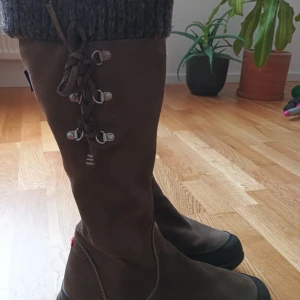 Bruna mockastövlar med snörning - Snygga bruna stövlar i mocka med snörning framtill. Perfekta för höst och vinter med en robust design och bekväm passform. De har en mörk sula som ger bra grepp.