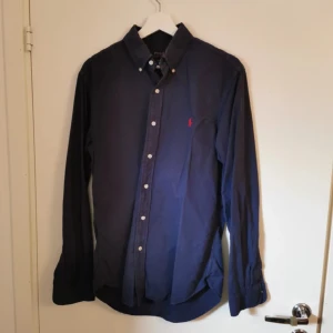 Mörkblå skjorta från Polo Ralph Lauren - Snygg mörkblå skjorta från Polo Ralph Lauren i slim fit. Perfekt under en stickad tröja samt för sig själv!