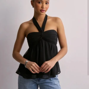 Svart topp med knytband från nelly - Jättesnygg svart topp från nelly med knytband som är perfekt på vår och sommar. Fråga för egna bilder