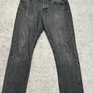 Grå svarta jeansbyxor Loose/Chris - Snygga grå jeansbyxor i loose fit-modell. Perfekta för en avslappnad stil. Midjemått w32 och längd 31. Klassisk design med fem fickor och knappgylf.