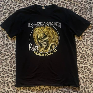  Iron Maiden t-shirt  - Cool svart t-shirt med Iron Maiden 'Killer World Tour '81' tryck. Tillverkad i mjuk bomull för en bekväm passform.