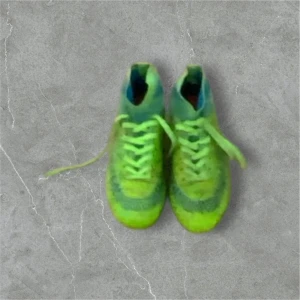 Gröna fotbollsskor med mönster - Snygga gröna fotbollsskor med unikt mönster i flera färger. Skorna har snörning och en hög ankelkrage för extra stöd. Perfekta för fotbollsplanen med sina dobbar för bra grepp.