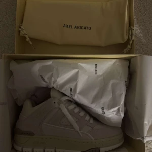 Sneakers från Axel Arigato - Stilrena sneakers från Axel Arigato i en ljus färg. Skorna har en modern design med snörning och en robust sula. 