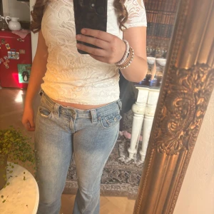 Vit spetsblus - Säljer en vit spetsblus med korta ärmar. Blusen har ett vackert blommigt mönster.💕