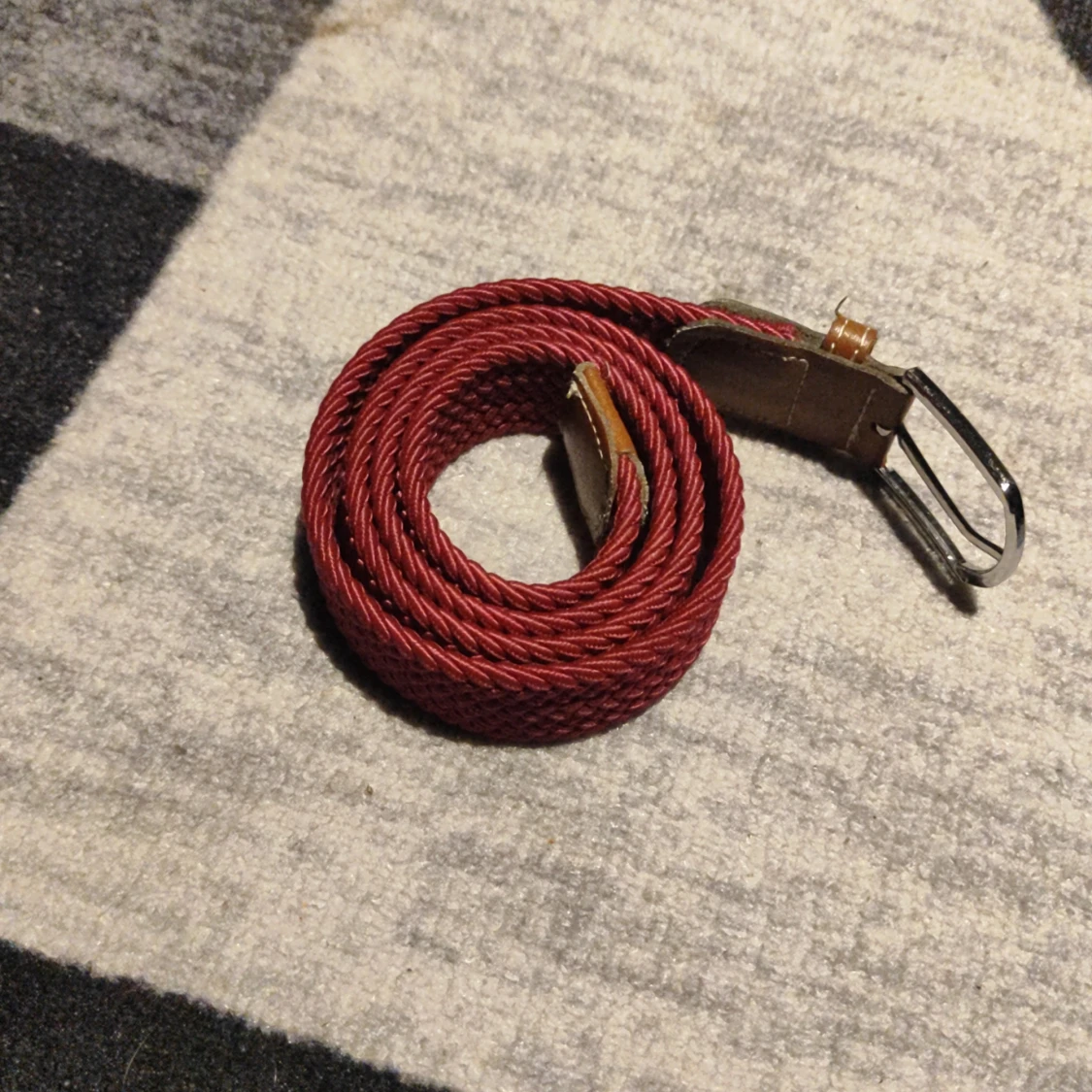 Rött flätat bälte med silverfärgat spänne