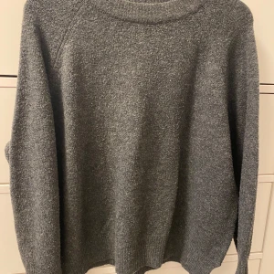 Grå stickad tröja Pull & Bear - Mörkgrå grovstickad tröja med sprund i sidorna.  Pull & Bear stl S.