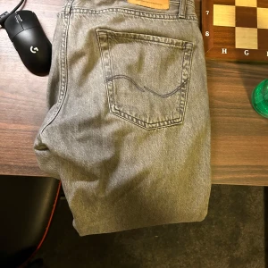 Grå jeans från Jack & Jones - tjena! Säljer nu dessa snygga gråa jeans från Jack & Jones. De har en rak passform och är tillverkade i ett slitstarkt denimtyg. Perfekta för en avslappnad stil. Pris går att diskutera vid snabb affär!
