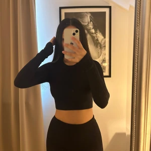 Svart croppad tröja och byxor från SOC - Snygg svart croppad tröja och träningsbyxor från SOC. Perfekt för träning eller en casual look. Tröjan och byxorna har en liten logga (SOC) på ryggen och är tillverkad i ett stretchigt material för bästa passform. Perfekt för gymmet! 💗