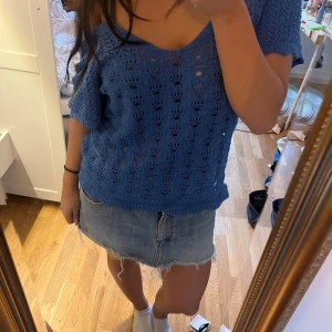 Blå stickad topp från ONLY - Säljer en blå stickad topp från ONLY med ett luftigt mönster. Toppen har korta ärmar och en avslappnad passform, perfekt för våren!💕
