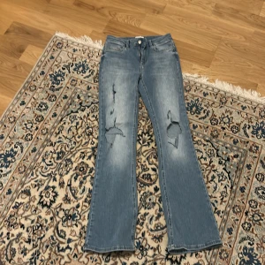 Fina blå jeans med slitningar från only - Blå low waist bootcut jeans från only med slitningar storlek S/30