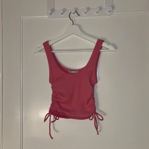 Rosa linnetopp med knyt - Snygg rosa linnetopp från Zara med knyt i sidorna för en justerbar passform. Perfekt för varma dagar och kan enkelt matchas med olika outfits.