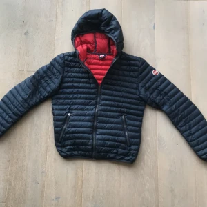 Mörkblå colmar jacka med huva - Snygg mörkblå vårjacka från colmar. Jackan är i bra skick förutom liten defekt (se bild 4) men det syns inte. Kontakta mig om ni undrar något.