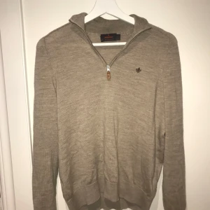 Beige ulltröja från Morris - Snygg beige tröja från Morris i 100% merinoull. Tröjan har en dragkedja framtill och en liten broderad logga på bröstet. Perfekt för kyligare dagar med sin mjuka och varma känsla. Tröjan är 9/10 skick då den inte har några synliga skador eller slitningar. Hör av er vid frågor!😁