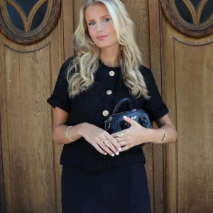 Svar blus/kofta med guldknappar - Elegant svart blus/kofta med korta ärmar och fina guldknappar. Perfekt för en elegant look. Väldigt eftertraktad och nypris 700kr!