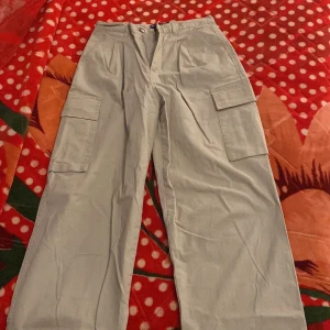 Beige cargobyxor från ASOS  - Säljer ett par beige cargobyxor från Ciso Design i storlek UK 20. Byxorna har flera praktiska fickor och en loose passform, perfekt för en avslappnad stil. De är i bra skick och passar utmärkt för höst och vår.