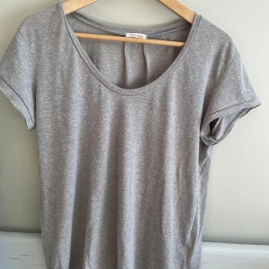 Grå t-shirt från Ragdoll - Säljer en stilren grå t-shirt från Ragdoll i bomullsmaterial. Den har en normal passform och korta ärmar, perfekt för vardagsbruk. T-shirten är i mycket bra skick och passar till alla säsonger. Enkelt och snyggt basplagg som funkar till allt!