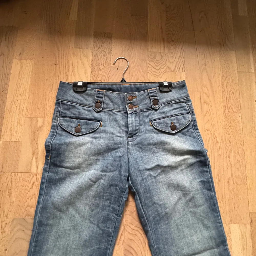 Säljer ett par snygga blå bootcut jeans i bra skick, förutom lite slitage längst ner. De har en lågmidjade och coola knapplösningar fram och är perfekt för någon som har lite längre. Jag säljer jeansen då de tyvärr inte passar mig i storlek eller i längden eftersom att de är så pass långa på mig. Skriv gärna om ni har några frågor💗. Jeans & Byxor.