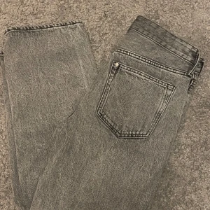 Grå jeans från H&M - Säljer ett par grå loose fit jeans från H&M i storlek 29/30. De är i bra skick och perfekta för en avslappnad stil. Tillverkade i Bangladesh, dessa jeans har en klassisk femficksdesign och en bekväm passform.