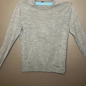 Merinoulls från Uniqlo - Säljer en stilren grå merinoull tröja från Uniqlo i storlek XS. Tröjan är långärmad och har en klassisk rund halsringning. Perfekt för en minimalistisk look. Kostar ca 500kr nu men släpper den för 200kr då den inte passar! Använd max 1 gång sen jag köpte den men eftersom den inte passade så säljer jag den! Hör av er vid minsta lilla fundering!