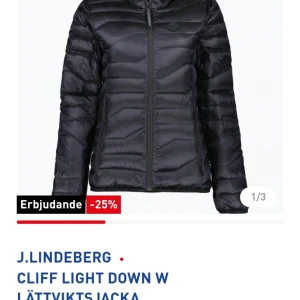 Svart lättviktsjacka från J.Lindeberg - Säljer en svart lättviktsjacka från J.Lindeberg. Jackan har en quiltad design med dragkedja och huva, perfekt för kyliga dagar. Den är stilren och funktionell, vilket gör den till ett mångsidigt plagg i garderoben. Superfint skick . 