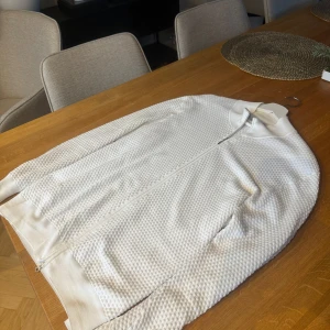 Vit bomullströja från Gran Sasso - Säljer en stilren vit tröja från Gran Sasso i 100% bomull. Tröjan har en dragkedja framtill och en diskret textur som ger den en unik look. Säljes då sen är för stor för mig| Väldigt mjuk och bekväm