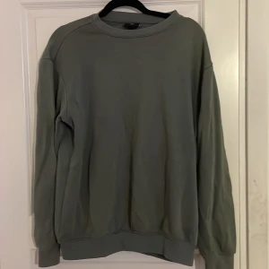 Grön sweatshirt - Säljer en stilren grön sweatshirt med rund hals och långa ärmar. Perfekt för en avslappnad look. Passar bra till både jeans och joggers. Storlek S