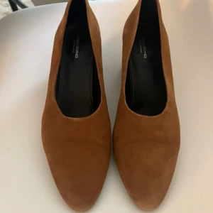 Bruna/cognacsfärgade  mockapumps från Vagabond   - Snygga bruna/cognacsfärgade mockapumps med en bekväm blockklack och spetsig tå. Perfekta för både vardag och fest! Endast använda ett fåtal ggr. Strlk 40. K