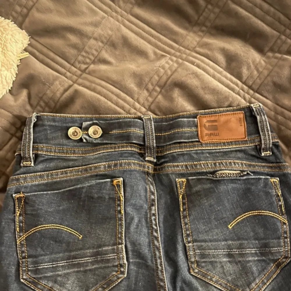 Säljer ett par snygga mörkblå bootcut jeans från G-Star RAW i storlek 24/34. De har en klassisk femficksdesign och är i mycket bra skick. Perfekta för både vardag och fest! . Jeans & Byxor.