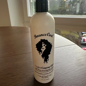 Bounce Curl Light Creme Gel - Bounce Curl Light Creme Gel med aloe och nigella sativa. Denna produkt är fri från parabener, sulfater och silikoner, och är designad för att ge definition och volym till lockigt hår. Perfekt för att hålla håret friskt och glänsande. Använd ett fåtal gånger. 