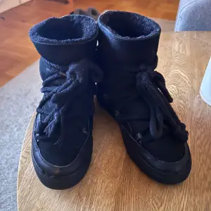 Säljer ett par svarta boots med varmt foder. De har snörning framtill och en högre skaftdesign som passar perfekt för kyligare dagar. Skorna är i bra skick och redo för nya äventyr. Perfekta för höst och vinter!