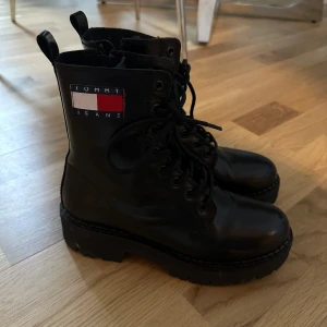 Svarta boots från Tommy Jeans - Snygga svarta boots från Tommy Jeans med snörning och en robust sula. Perfekta för en cool och stilren look och för vintern. Märkets logga syns tydligt på sidan av skorna. Helt nya då jag fick dom i present och använt 1 gång 