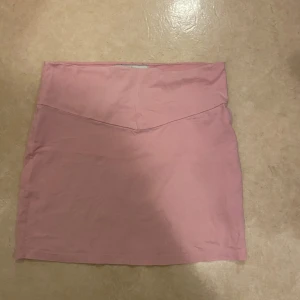 Rosa kjol - Säljer en söt rosa kortkjol i en enkel design. Perfekt för en avslappnad stil. Kjolen har en mjuk och bekväm passform. Vet ej vart den är ifrån då jag fick den av en vän