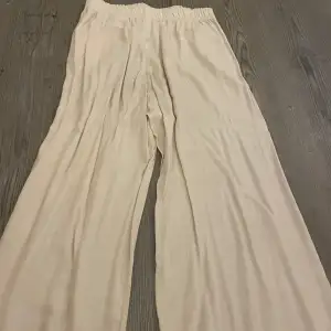 Säljer ett par superbekväma beige byxor från H&M i storlek M. De har en loose passform och är perfekta för en avslappnad stil. Byxorna är högmidjade med elastisk midja för extra komfort. Perfekta för vår och sommar!