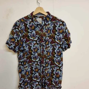 Blommig kortärmad skjorta från Black Label - Snygg blommig skjorta från Black Label med korta ärmar. Skjortan har ett färgglatt mönster i blått, vitt och rött med knappar framtill. Perfekt för en somrig look!