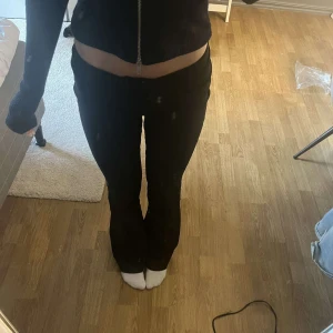 Svarta lågmidjade kostymbyxor  - Snygga svarta kostymbyxor. De har en bootcut passform och är perfekta för en stilren look. Byxorna är lågmidjade och passar bra till olika tillfällen.