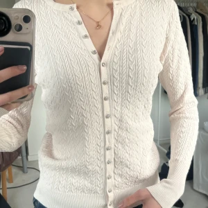 rosa kabelstickad kofta från Zara - Säljer en stilren rosa/beige kabelstickad kofta från Zara med knappar framtill. De står storlek L men skulle säga att den passar s 