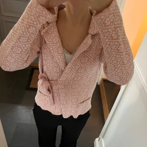 Rosa stickad omlottkofta - Rosa mönstrad kofta med snörning från Seaside i storlek S. Fint skick. Använd gärna köp nu!