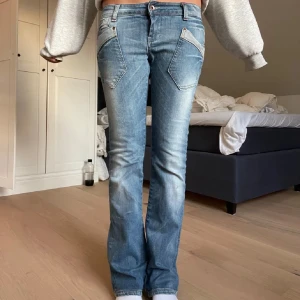 Blå bootcut jeans - Snygga blå bootcut jeans med låg midja och unika fickdetaljer fram. Perfekta för en avslappnad stil med en touch av retro. De har en klassisk femficksdesign och en lätt tvättad look. ( lånade bilder )