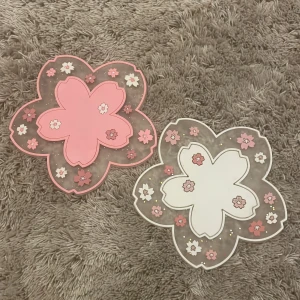Glas underlägg - Två stycken sakura glas underlägg. Andvända men syns inte så mycket efter som att det är mjukt plast.