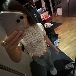 Vit spetsblus - Säljer en söt vit spetsblus med korta ärmar och volangdetaljer. Blusen är croppad och har ett fint mönster som ger en romantisk känsla. Perfekt för varmare dagar eller sommarens fester. Säljer den på grund av att jag aldrig använt den och den är i jätte bra skick. Original priset är 350kr 