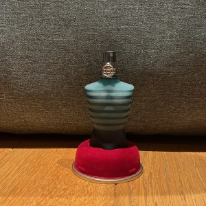 Le Male Eau de Toilette från Jean Paul Gaultier -  Jean paul gaultier som är hel full och ny Ikonisk parfymflaska formad som en manlig torso i blått och svart med horisontella ränder. Kommer med en metallisk cylinderförpackning. Perfekt för den som vill ha en klassisk och distinkt doft.