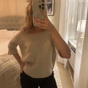 Beige stickad tröja - Mysig beige stickad tröja med trekvartsärm. Perfekt för en avslappnad stil och enkel att matcha med olika outfits. Ifrån soaked in luxury