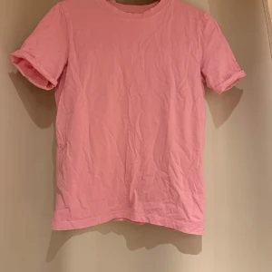 Rosa t-shirt från Pieces - Säljer en enkel och stilren rosa t-shirt från Pieces. Den har korta ärmar och är gjord i mjukt bomullsmaterial. Perfekt för en avslappnad look. Passar bra till jeans eller shorts. 🌸