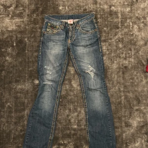 Blå jeans från True Religion - Snygga blå jeans från True Religion med gula sömmar och slitna detaljer. 
