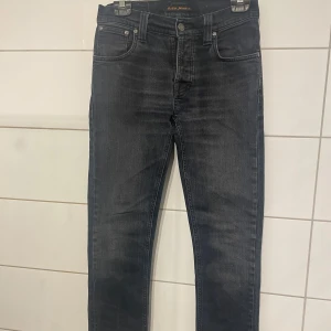 Svarta jeans från Nudie Jeans - Snygga svarta jeans från Nudie Jeans med klassisk femficksdesign och subtila detaljer. Jeansen är köpta på nk Gbg och säljs då dom inte längre passar. Storlek 28/34 men passar 28/32 skriv vid fler funderingar!