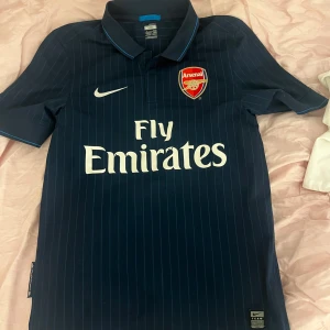 Mörkblå Arsenal fotbollströja  -  mörkblå Arsenal fotbollströja i storlek S. enda anmärkningen är trycket på vissa ställen