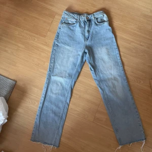 Jeans - Snygga ljusblå jeans från NA-KD med en avslappnad passform. De har en klassisk femficksdesign och råa kanter vid bensluten för en trendig look. Perfekta för en casual stil.