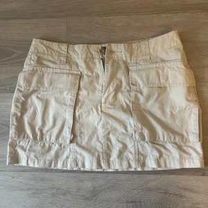 Beige cargo kjol - Kort kjol från lager 157. Använd fåtal gånger. Skriv gärna om du har frågor eller vill ha fler bilder.